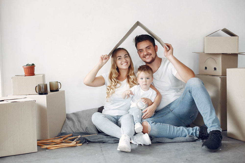 Una pareja feliz con su hijo bajo un techo sonriendo